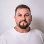 Мужчина в белой майке улыбается на белом фоне